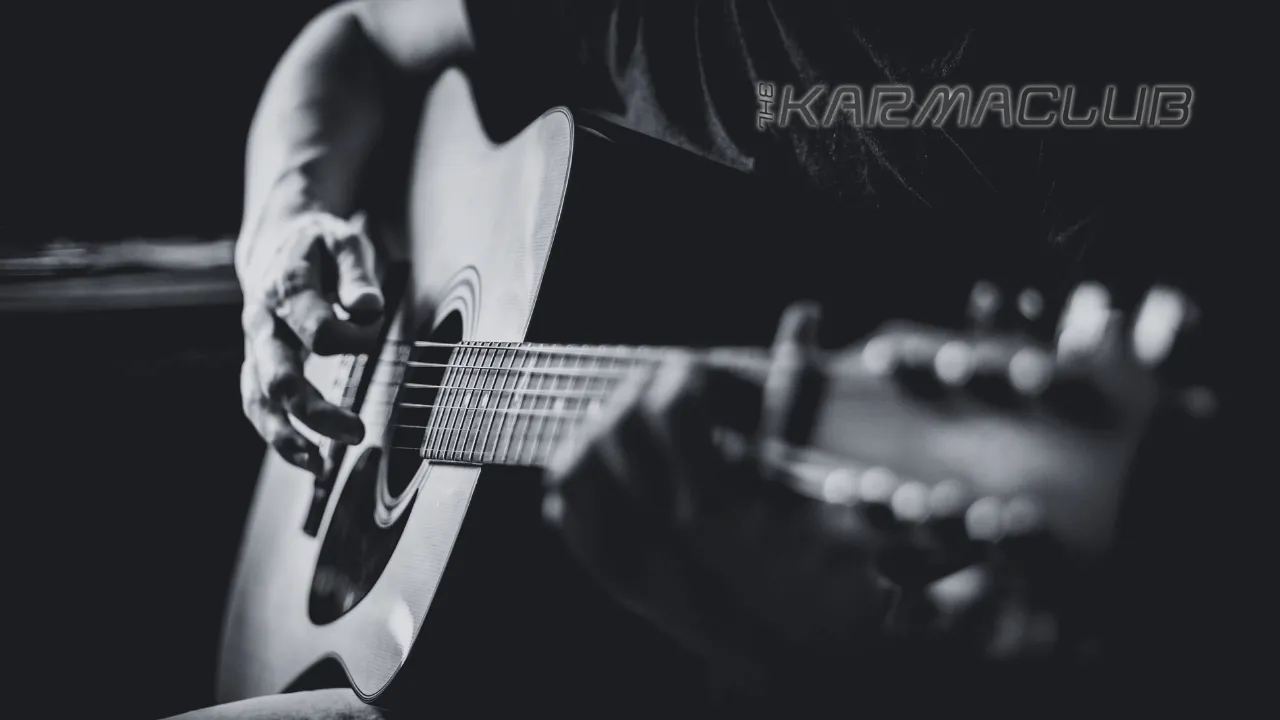 Close-up of a musician playing an acoustic guitar in black and white with Karma Club logo